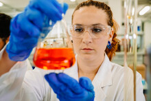 Serious Chemist Examining Liquid In Flask In Lab