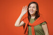 © ViDi Studio - Young curious nosy happy woman 20s in khaki t-shirt tied sweater on shoulders try to hear you overhear listening intently isolated on plain orange background studio portrait. People lifestyle concept.