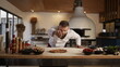 © stockbusters - Man cooking pizza in italian food restaurant. Chef adding ingredients on pastry.