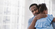 © paulaphoto - Portrait of american african father daughter hugging laughing in living room. Happy daddy and little girl spending leisure time at home. Single dad, family lifestyle father's day concept banner