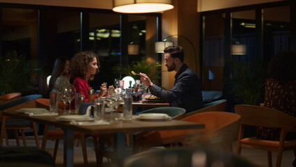 Loving couple eating together in restaurant. Two people share dinner date food.