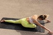 © JustLife - Beautiful young woman practising yoga outside. Fit woman doing yoga stretching exercises.