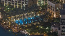 Aerial View Of Swimming Pool Relaxing Zone In Old Town Island From Above Night Timelapse. Dubai Downtown With Illuminated Traditional Buildings
