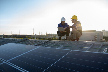 Engineers team survey check solar panel roof.Technician professional engineer with labtop and tablet maintenance checking installing solar roof panel on the factory rooftop under sunlight.
