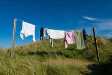 Hirtshals, Denmark Laundry Drying On A Clothes Line Outdoors Between Posts.