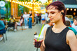 © pavel siamionov - young woman holding a plastic glass with a drink on the street