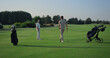 © stockbusters - Active men enjoy golf on course field. Two golfers teeing play sport outside.