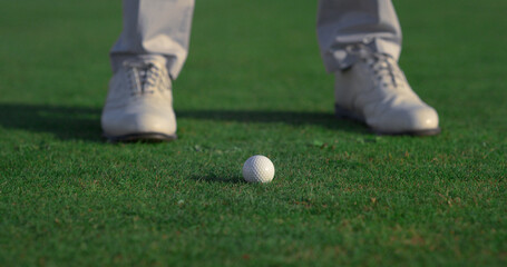 Wall Mural - Golfer feet hitting ball on fairway course. Golf man swinging shot on training.