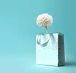 White flower in shopping bag on pink background. Floral composition, copy space
