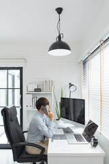 Wall Mural - software development concept, male programmer talking on smartphone and check data code on monitor