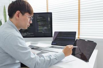 Wall Mural - software development concept, male programmer point data on tablet to checking website programming