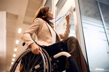 Wall Mural - Close up of businesswoman with disability using ID card to enter in the office.