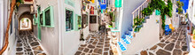 Traditional Greece, White Paved Narrow Streets Of Paros Island,  Cyclades. Popular Touristic Place In Old Town Of Chora With Cute Shops And Bars. May 2021