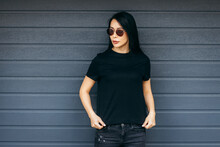 Stylish Brunette Asian Girl Wearing Black T-shirt And Sunglasses Posing Against Street , Urban Clothing Style. Street Photography