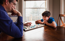 Boy And His Father Having Fun Playing A Game Together At Home.