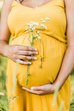 Detail Of Flowers And A Yellow Dress On Pregnant Woman
