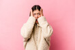 © Asier - Young Chinese woman isolated on pink background covering ears with hands trying not to hear too loud sound.