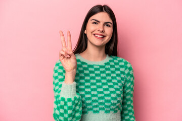 Wall Mural - Young caucasian woman isolated on pink background showing number two with fingers.