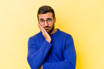 Wall Mural - Young caucasian man isolated on yellow background who is bored, fatigued and need a relax day.