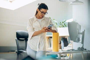 Wall Mural - Female digital designer talking on the phone in an office