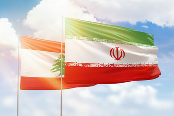 Sunny blue sky and flags of iran and lebanon