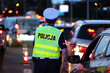 Policjantka kieruje ruchem drogowym wieczorem podczas szczytu w korkach ulicznych. 
