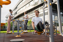 Group Of Friends Man And Women Male And Young Adult People Training At Outdoor Open Gym In Park In Front Of Modern Building Real People Sport And Recreation Exercise Healthy Lifestyle Concept