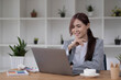 © wichayada - Beautiful smiling young graphic designer sitting at desk in office and working