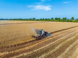 © ABCDstock - Harvesters work on the farm. Combine harvester agricultural machine is harvesting golden ripe wheat field. Agricultural scene. Aerial view from above.
