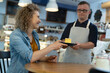 © gpointstudio - Caucasian man with down syndrome serving a piece of cake in the cafe