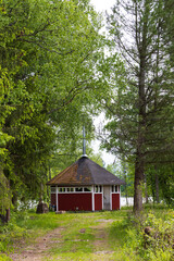 Wall Mural - Typical Finnish little wooden shed with fire place along lake at the countryshide