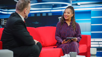 Talk Show TV Program, News Interview and Discussion: Presenter and Guest Talk. Cable Channel Hosts Have Friendly Conversation. Mock-up Television Studio and Newsroom Entertainment Concept