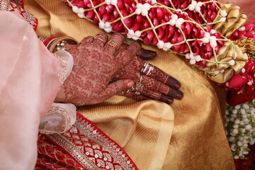 Wall Mural - mom and daughter holding each other hands with mehndi designs just before the wedding.