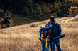 Couple with backpacks hiking together in nature on autumn day.