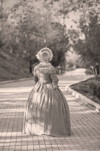 Woman In Victorian Dress Walking In The Park. Vintage Fashion.