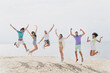 © deagreez - Full size portrait of active cheerful buddies rejoice jumping sand beach water sea outdoors