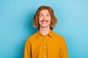 Poster - Portrait of attractive cheerful long-haired guy looking up thinking making decision isolated over bright blue color background