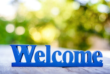 blue welcome text on wooden table in restaurant