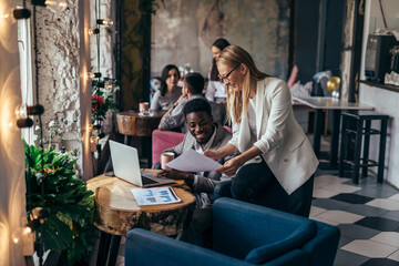 Wall Mural - During a coffee break, a woman approached her partner with papers