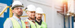 Portrait of group engineers wearing helmet on production site. Team of caucasian workers standing in a line. Wide image