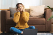 © itchaznong - Portrait of Happy Asian artist woman using smart phone and listen music at home. Relax concept.