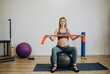 Pregnant woman doing relax exercises with a fitness pilates ball at home