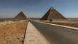 Popular tourist destination ancient Egyptian Giza city ruins of the pyramids of Gizeh close to Cairo with the Pyramid of the Cheops and the Pyramid of Chephren and prehistoric stone walls tombs