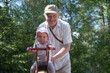 Caucasian grandfather father swinging baby at a playground