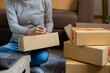 © Natee Meepian - Shipping shopping online, young start up small business owner writing address on cardboard box at workplace.small business entrepreneur SME or freelance asian woman working at home