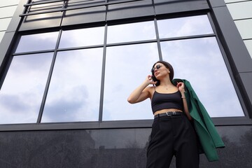 Portrait of a businesswoman who is talking on the phone on the street