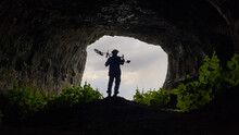 Treasure Hunter With Metal Detector Searching Inside The Cave In The Historical Texture
