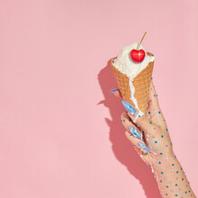 Summer Creative Layout With Woman Hand With Sparkle Stones Holding Melting Ice Cream Cone With Cherry On Pastel Pink Background.  70s, 80s Or 90s Retro Aesthetic Fashion Idea. 