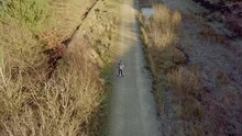 Young Boy Riding Down A Country Pathway On A Hoverboard. Filmed In Winter With Frost On The Ground.