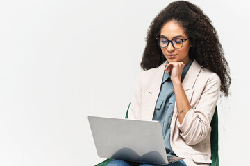 Smart and confident African-American woman in smart wear using laptop isolated on white background, female office employee or student typing, web browsing